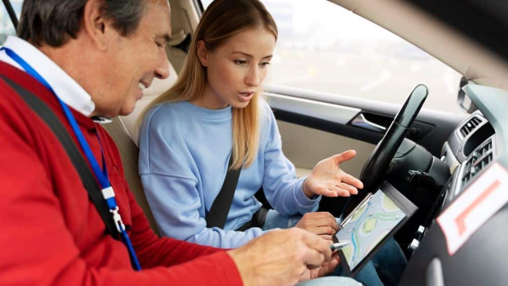 Simbolna fotografija inštruktorja vožnje in učenke.