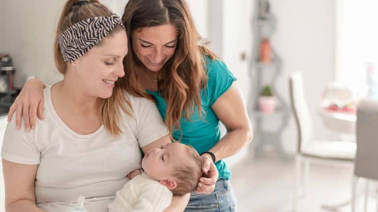 Na sliki sta dve mamici z novorojenčkom.